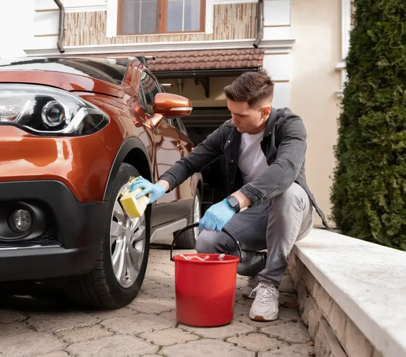 Lavage auto à domicile Recoules-d'Aubrac : professionnel intervenant sur un véhicule